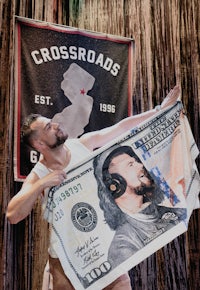 a man holding up a dollar bill in front of a stage