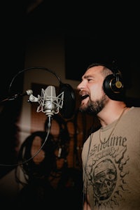 a man singing into a microphone in a recording studio